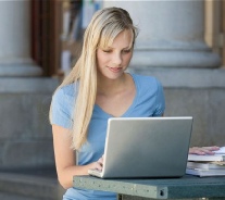 Esencia Girl relaxed with on-line learning with Computer ready on the desk.